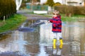 Little kid boy playing with fishing rod by puddle Royalty Free Stock Photo