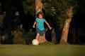 Little kid boy playing football in the field with soccer ball. Concept of children sport. Child soccer player in park. Royalty Free Stock Photo