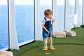 Little kid boy playing mini golf on a cruise liner. Royalty Free Stock Photo