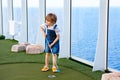 Little kid boy playing mini golf on a cruise liner. Royalty Free Stock Photo