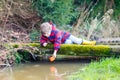 Little kid boy playing with paper boat by puddle Royalty Free Stock Photo