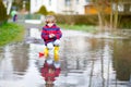 Little kid boy playing with paper ship by puddle Royalty Free Stock Photo