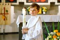 Little kid boy receiving his first holy communion. Happy child holding Christening candle. Tradition in catholic curch Royalty Free Stock Photo