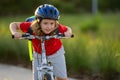 Little kid boy ride a bike in the park. Kid cycling on bicycle. Happy smiling child in helmet riding a bike. Boy start Royalty Free Stock Photo