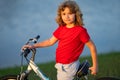 Little kid boy riding a bike in summer park. Child drive a bike on a driveway outside. Kid riding bikes in the city Royalty Free Stock Photo