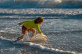 Little kid boy running on the beach on sunrise. Happy amazed kid running on sea beach. Cute child running near ocean on Royalty Free Stock Photo