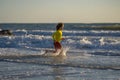 Little kid boy running on the beach on sunrise. Happy amazed kid running on sea beach. Cute child running near ocean on Royalty Free Stock Photo