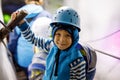 Little kid boy with safety helmets inside of glacier with ice tunnel. Schoolkid hiking and discovering mountain in Tirol