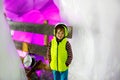 Little kid boy with safety helmets inside of glacier with ice tunnel. Schoolkid hiking and discovering mountain in Tirol