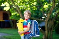 Little kid boy with school satchel on first day to school