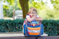 Little kid boy with school satchel on first day to school