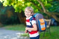 Little kid boy with school satchel on first day to school