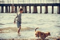 Little kid boy at sea water with dog. Summer. Royalty Free Stock Photo