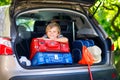 Little kid boy sitting in car trunk just before leaving for vaca Royalty Free Stock Photo