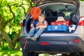 Little kid boy sitting in car trunk just before leaving for vaca Royalty Free Stock Photo