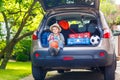 Little kid boy sitting in car trunk just before leaving for vaca Royalty Free Stock Photo