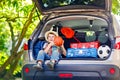 Little kid boy sitting in car trunk just before leaving for vaca Royalty Free Stock Photo