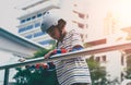 Little boy skater is resting on side fence after skating in the skate park Royalty Free Stock Photo