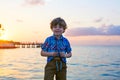 Little kid boy at sunset near ocean Royalty Free Stock Photo