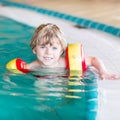 Little kid boy with swimmies learning to swim in Royalty Free Stock Photo