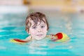 Little kid boy with swimmies learning to swim in an indoor pool Royalty Free Stock Photo