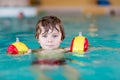 Little kid boy with swimmies learning to swim in an indoor pool Royalty Free Stock Photo