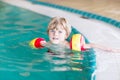 Little kid boy with swimmies learning to swim in an indoor pool Royalty Free Stock Photo