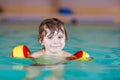 Little kid boy with swimmies learning to swim in an indoor pool Royalty Free Stock Photo