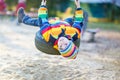 Little kid boy swinging on playground outdoors Royalty Free Stock Photo