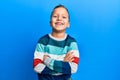 Little kid boy wearing striped sweater happy face smiling with crossed arms looking at the camera Royalty Free Stock Photo