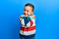 Little kid boy wearing striped sweater hugging oneself happy and positive, smiling confident Royalty Free Stock Photo