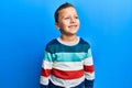 Little kid boy wearing striped sweater looking to side, relax profile pose with natural face and confident smile Royalty Free Stock Photo