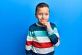 Little kid boy wearing striped sweater smiling looking confident at the camera with crossed arms and hand on chin Royalty Free Stock Photo