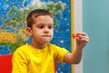 Little kid boy in yellow t-shirt playing with lots of colorful plastic blocks indoor. Child having fun with building and creating Royalty Free Stock Photo