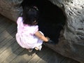 Little kid peeping into a log hole