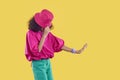 African American child in pink bucket hat doing moonwalk isolated on yellow background Royalty Free Stock Photo