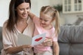 Little kid daughter embracing happy mom reading mothers day postcard Royalty Free Stock Photo