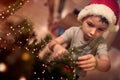 A little kid focused on ornamenting a Christmas tree at home. Together, New Year, family, celebration