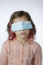 Little kid girl with the eyes closed by mask during coronavirus epidemy