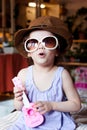 Little kid girl having fun with toy guitar in arms and sunglasses on face. Royalty Free Stock Photo