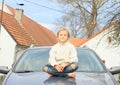 Little kid - girl on hood of car Royalty Free Stock Photo