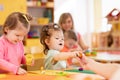 Little kid girl learning to use colorful play dough in kindergarten Royalty Free Stock Photo