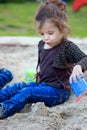 Little kid girl playing in a children sandbox Royalty Free Stock Photo