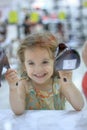 Little kid girl in a shoes store with the shoes on a shop-window. Royalty Free Stock Photo