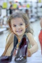 Little kid girl in a shoes store with the shoes on a shop-window. Royalty Free Stock Photo