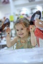 Little kid girl in a shoes store with the shoes on a shop-window. Royalty Free Stock Photo