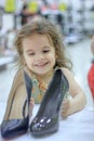 Little kid girl in a shoes store with the shoes on a shop-window. Royalty Free Stock Photo