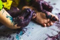 Little kid hands and feet covered with multiple colours