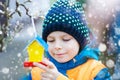 Little kid hanging bird house on tree for feeding in winter Royalty Free Stock Photo