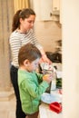 Little kid helps his mother to cook